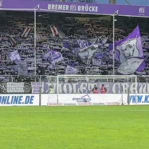 Die Fans in der Ostkurve der Bremer Brücke halten ihre Schals hoch