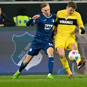 Stuttgarts Alexander Nübel und Maximilian Beier von der TSG Hoffenheim im Duell.