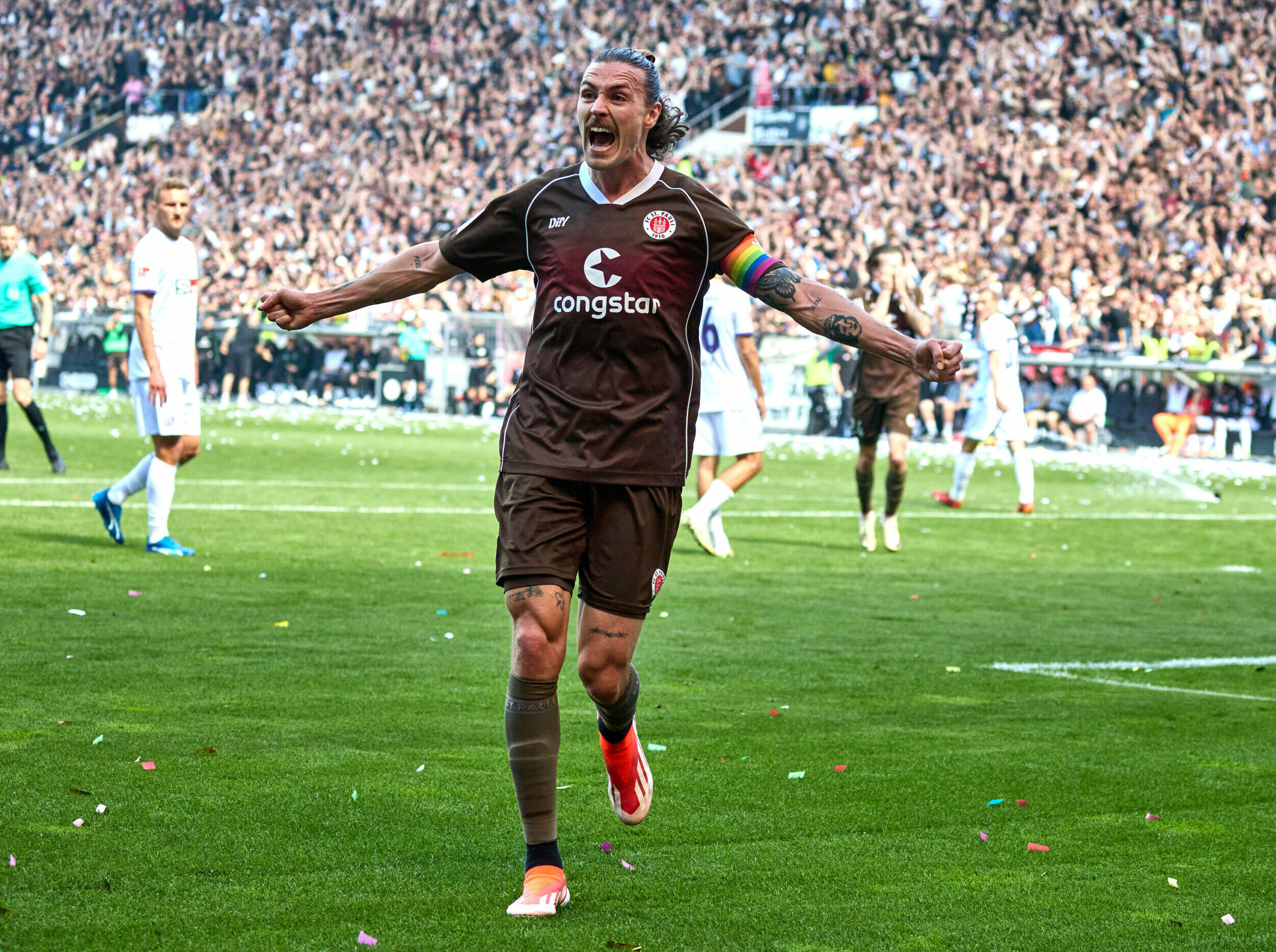 St. Pauli-Kapitän Jackson Irvine breitet die Arme aus und jubelt