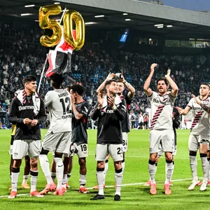 Die Leverkusen-Spieler jubeln mit einem golden Ballon mit in Form einer 50.