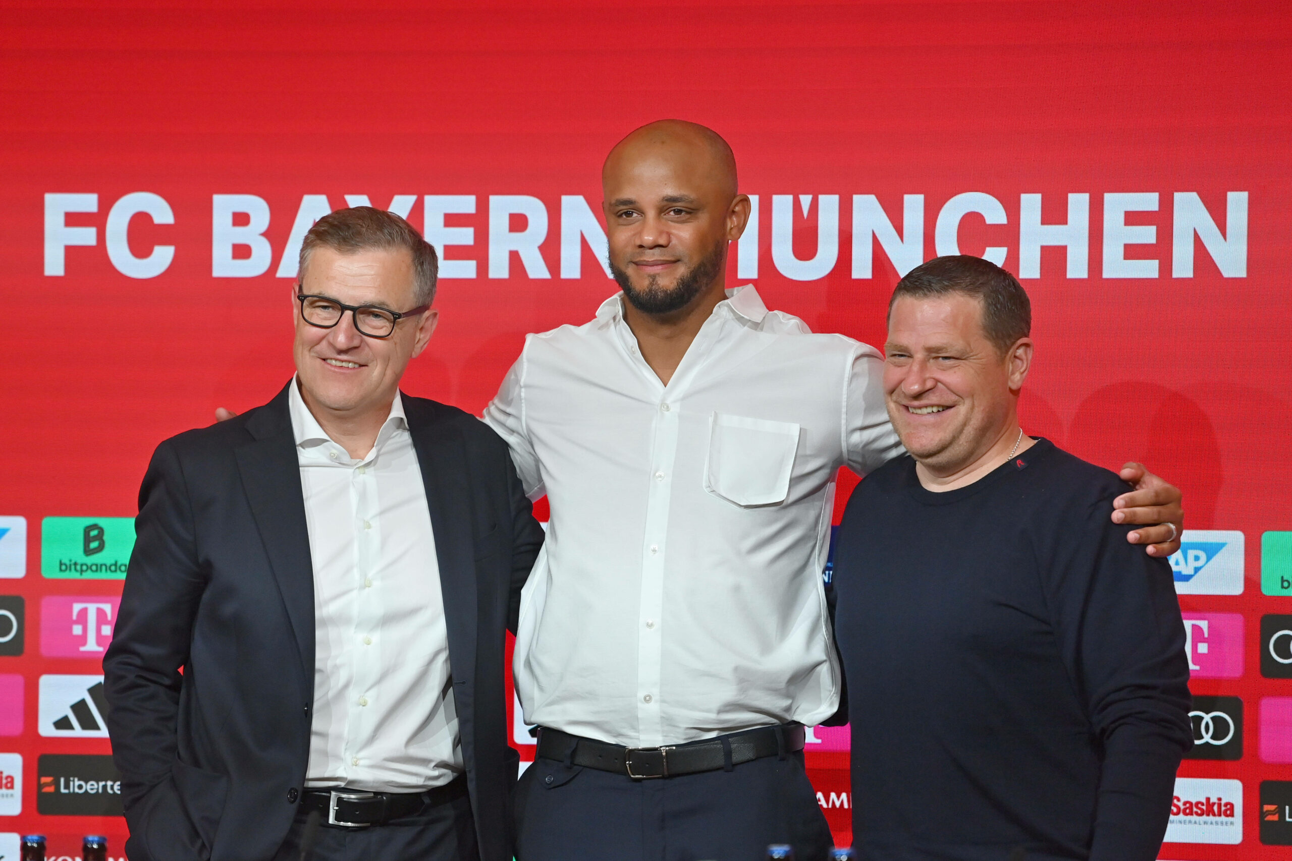 Vincent Kompany, Jan-Christian Dreesen und Max Eberl stehen Arm in Arm bei Kompany Vorstellung auf der Pressekonferenz