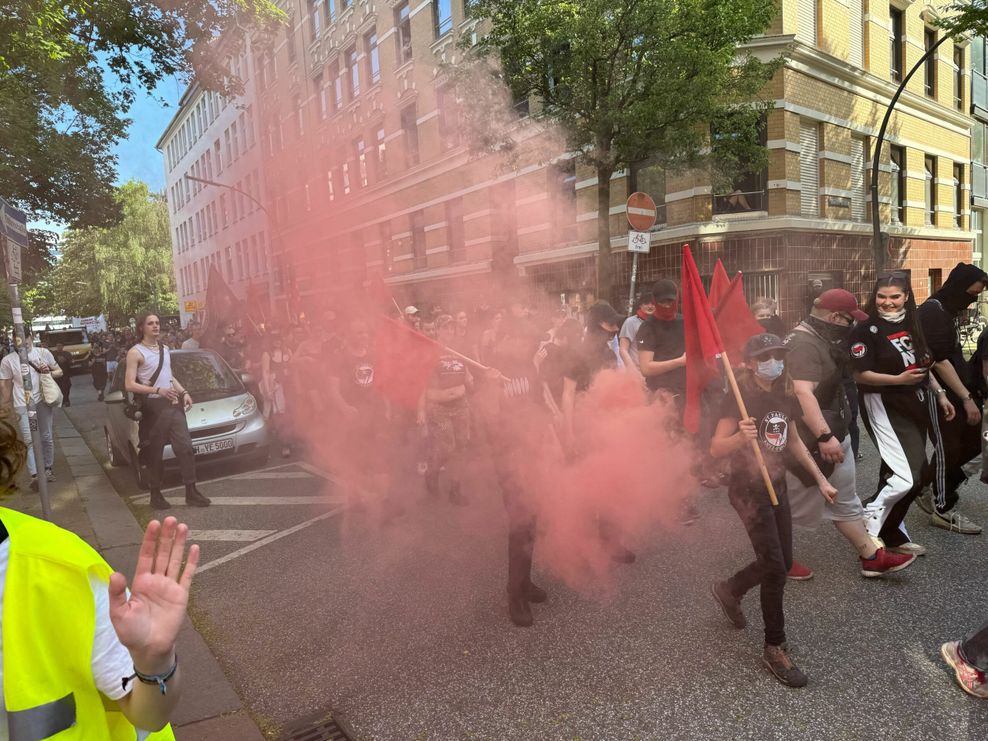 Bei der Demo durch St. Georg zünden Teilnehmer vereinzelt Pyrotechnik.