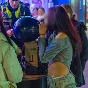 Auch in Hamburg ist Lachgas beliebt – hier konsumieren Jugendliche die Party-Droge vor den Augen eines Polizisten auf der Reeperbahn.