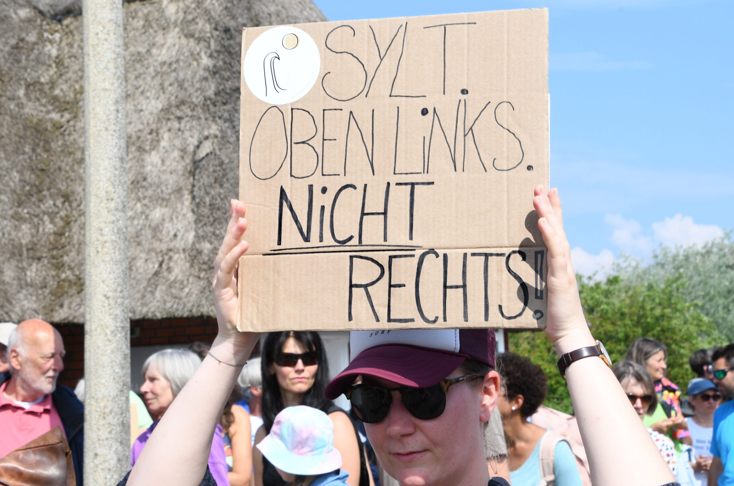 „Sylt. Oben links. Nicht rechts", steht auf dem Plakat einer Teilnehmerin der Mahnwache am Sonntag auf der Straße Strönwai.