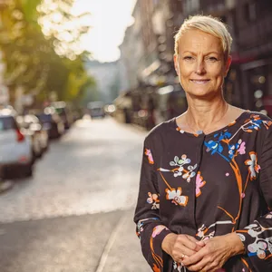 Frau in geblümten Kleid vor Straße
