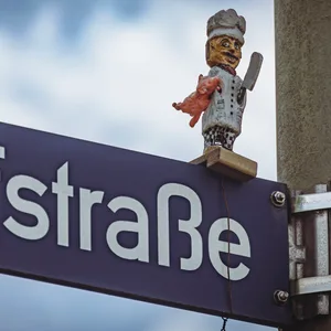Die Holzfigur eines Schlachters steht auf dem Schild der Schlachthofstraße