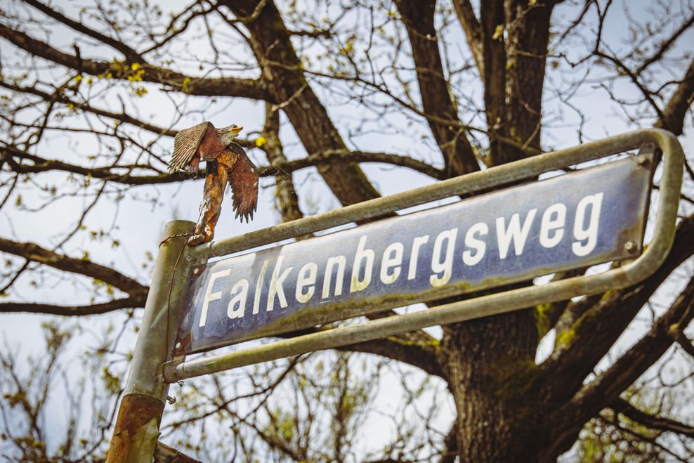Auf dem Straßenschild zum Falkenbergsweg thornt ein Falkner mit seinem Greifvogel.