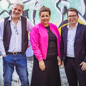 Gruppenbild: Vier Männer und eine Frau mit pinkem Blouson