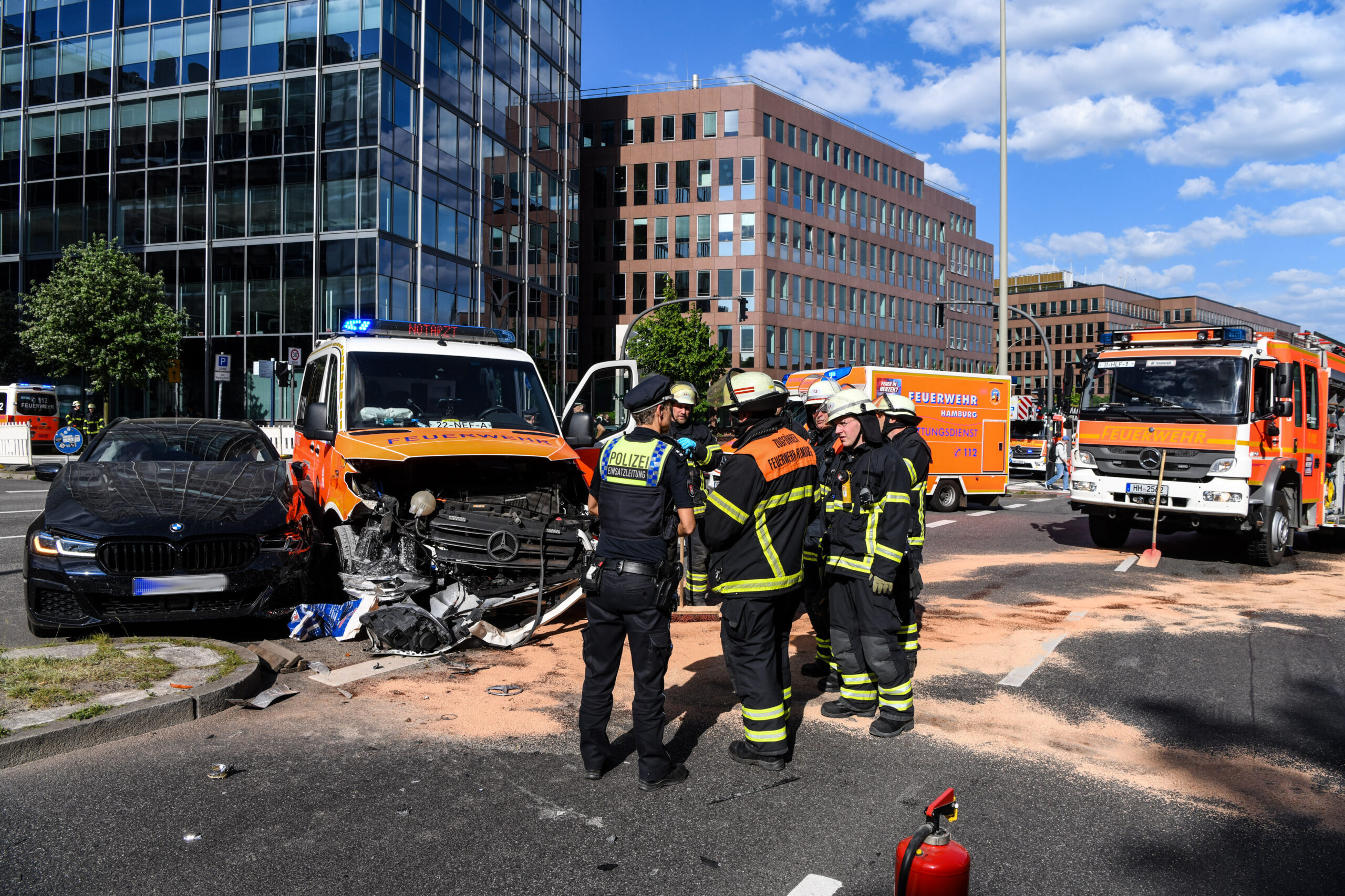 Einsatzkräfte der Feuerwehr und Polizei stehen am Unfallort