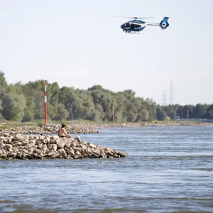 Ein Hubschrauber fliegt über dem Rhein