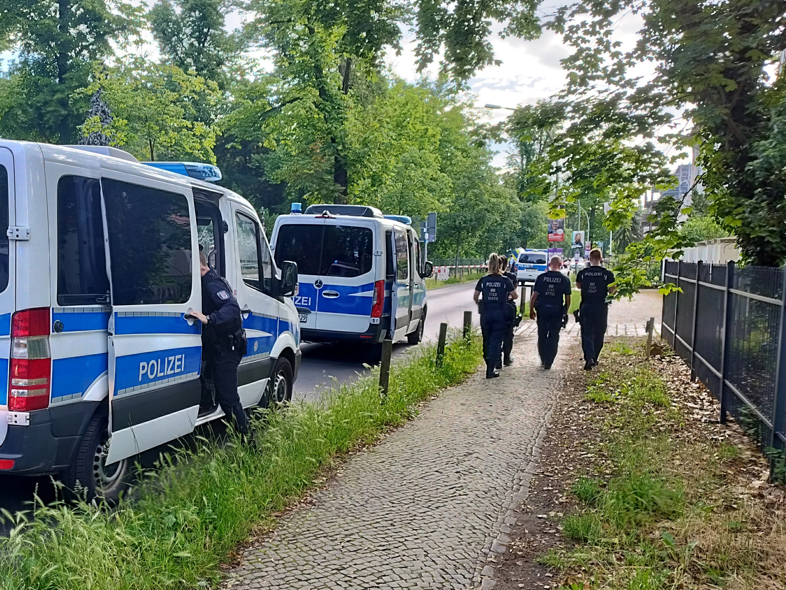 Potsdam: Polizisten gehen am abgesperrten Tatort in der Potsdamer Geschwister-Scholl-Straße entlang. Ein Wachmann in einer Gemeinschaftsunterkunft für Geflüchtete ist schwer verletzt worden.