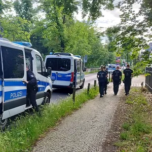 Potsdam: Polizisten gehen am abgesperrten Tatort in der Potsdamer Geschwister-Scholl-Straße entlang. Ein Wachmann in einer Gemeinschaftsunterkunft für Geflüchtete ist schwer verletzt worden.