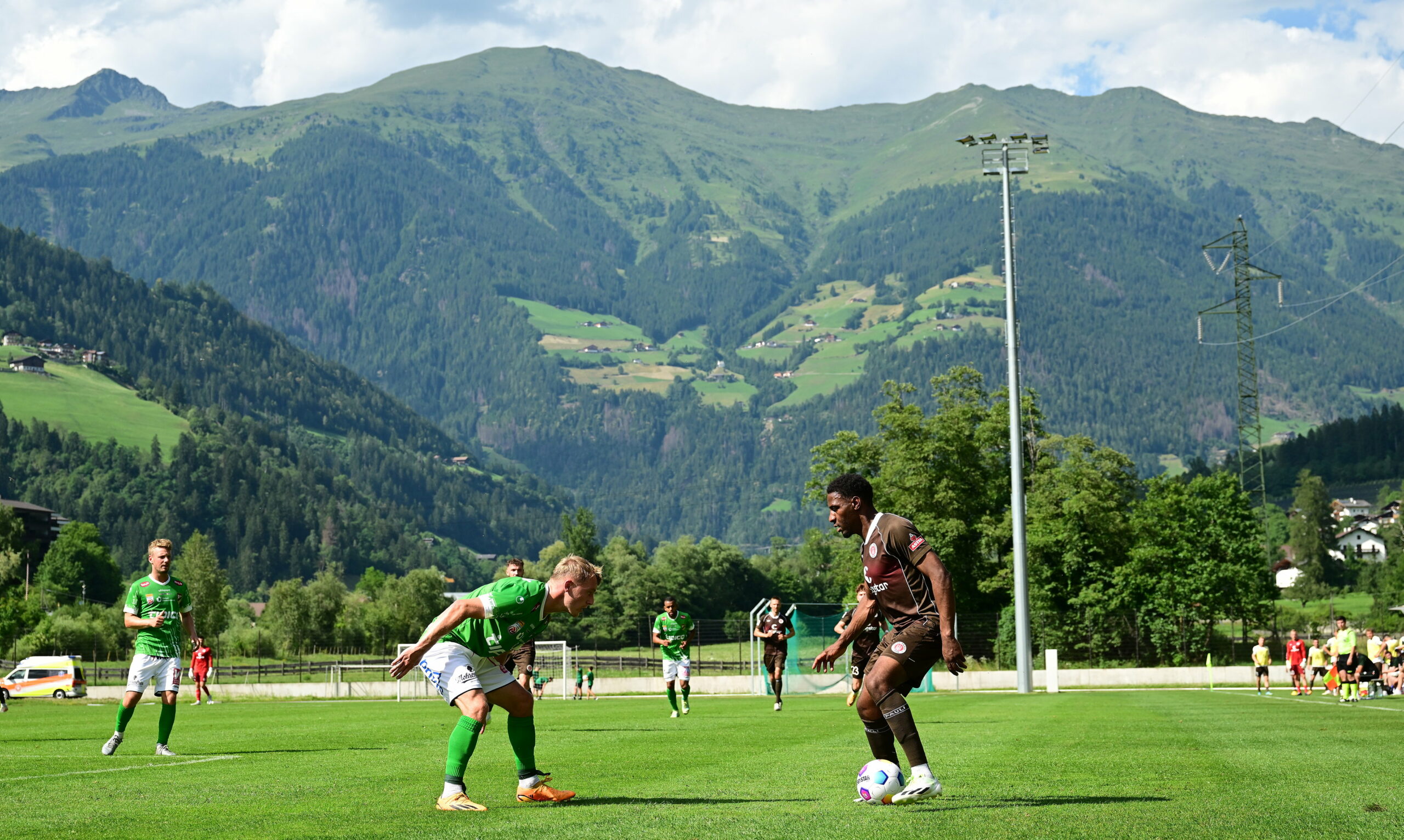 Oladapo Afolayan setzt vor einer Bergkulisse zum Dribbling an