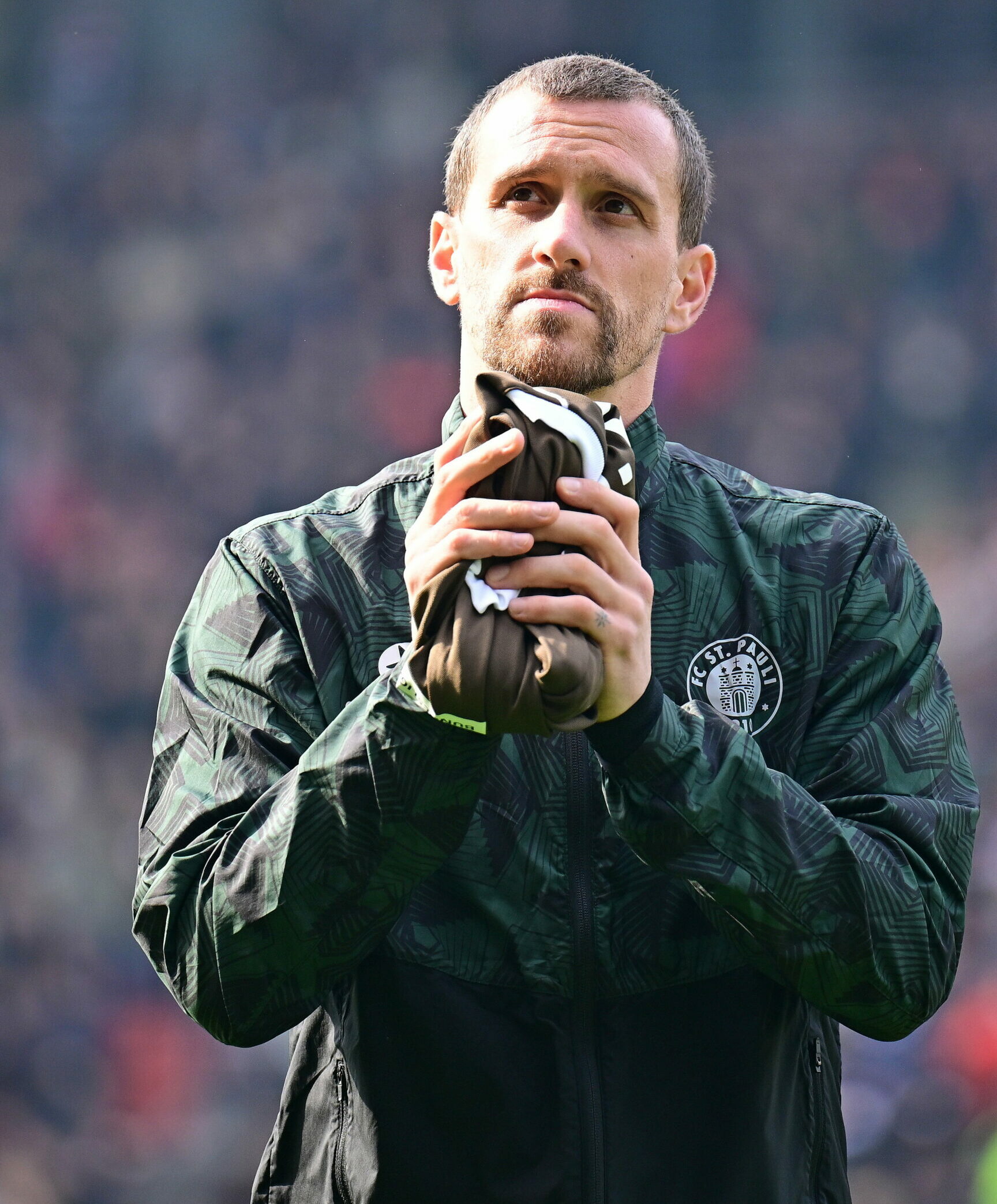 Simon Zoller vom FC St. Pauli mit einem Trikot in der Hand