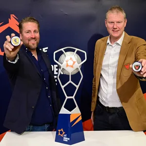 Oliver Roggisch von den Rhein-Neckar Löwen (l.) und Volker Zerbe von den Füchsen Berlin posieren nach der Auslosung der EHF Finals mit dem Pokal