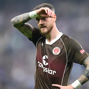 Marcel Hartel hält sich die Hand vors Gesicht