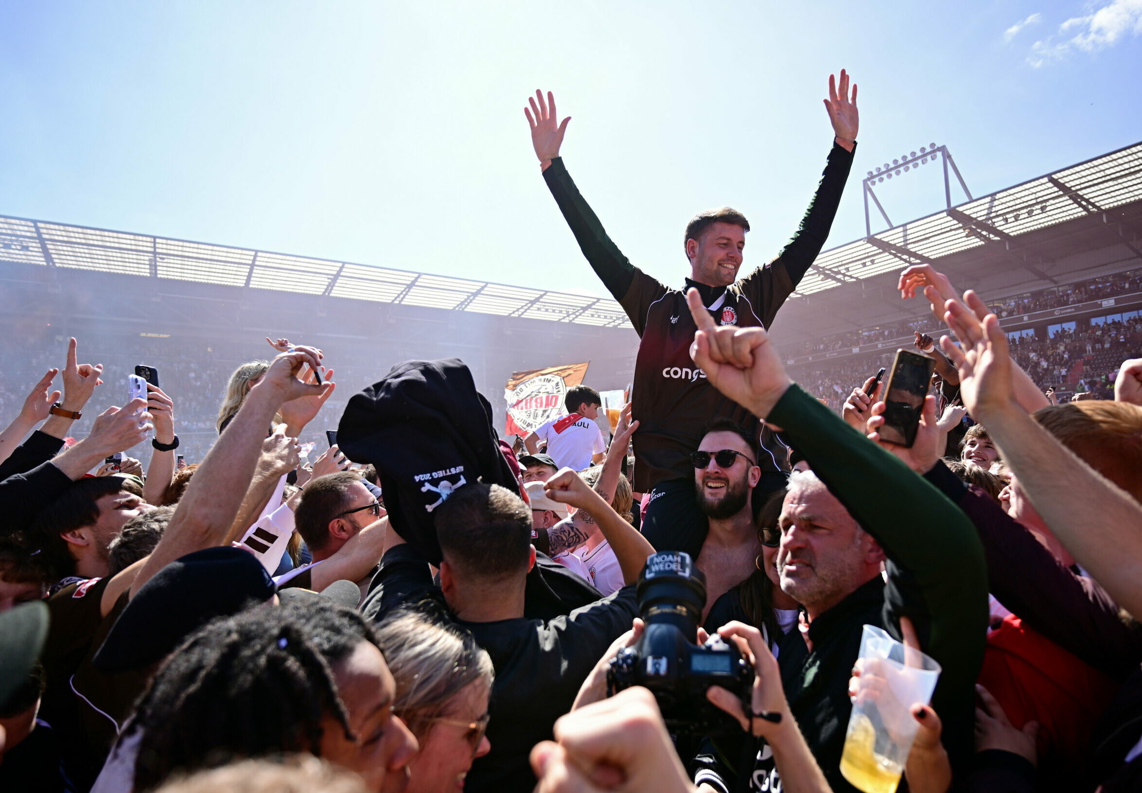 St. Pauli-Trainer Fabian Hürzeler wird von Fans auf Schultern über den Stadionrasen getragen