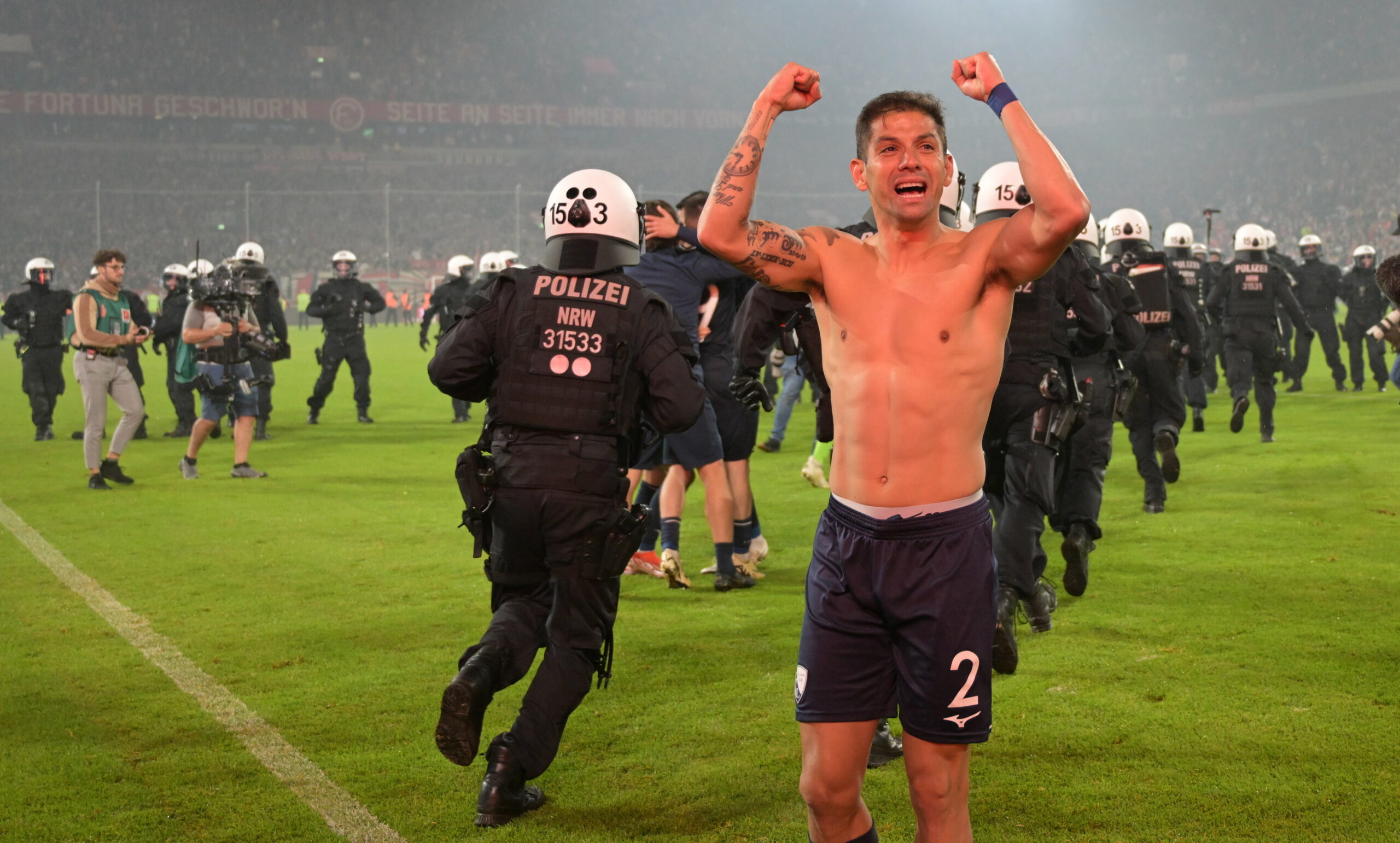 Bochums Cristian Gamboa musste sich beim Feiern mit den eigenen Fans erst einmal seinen Weg durch die aufs Feld stürmenden Polizisten bahnen.