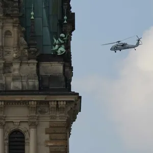 Ein Helikopter der US Army kreist um das Hamburger Rathaus.