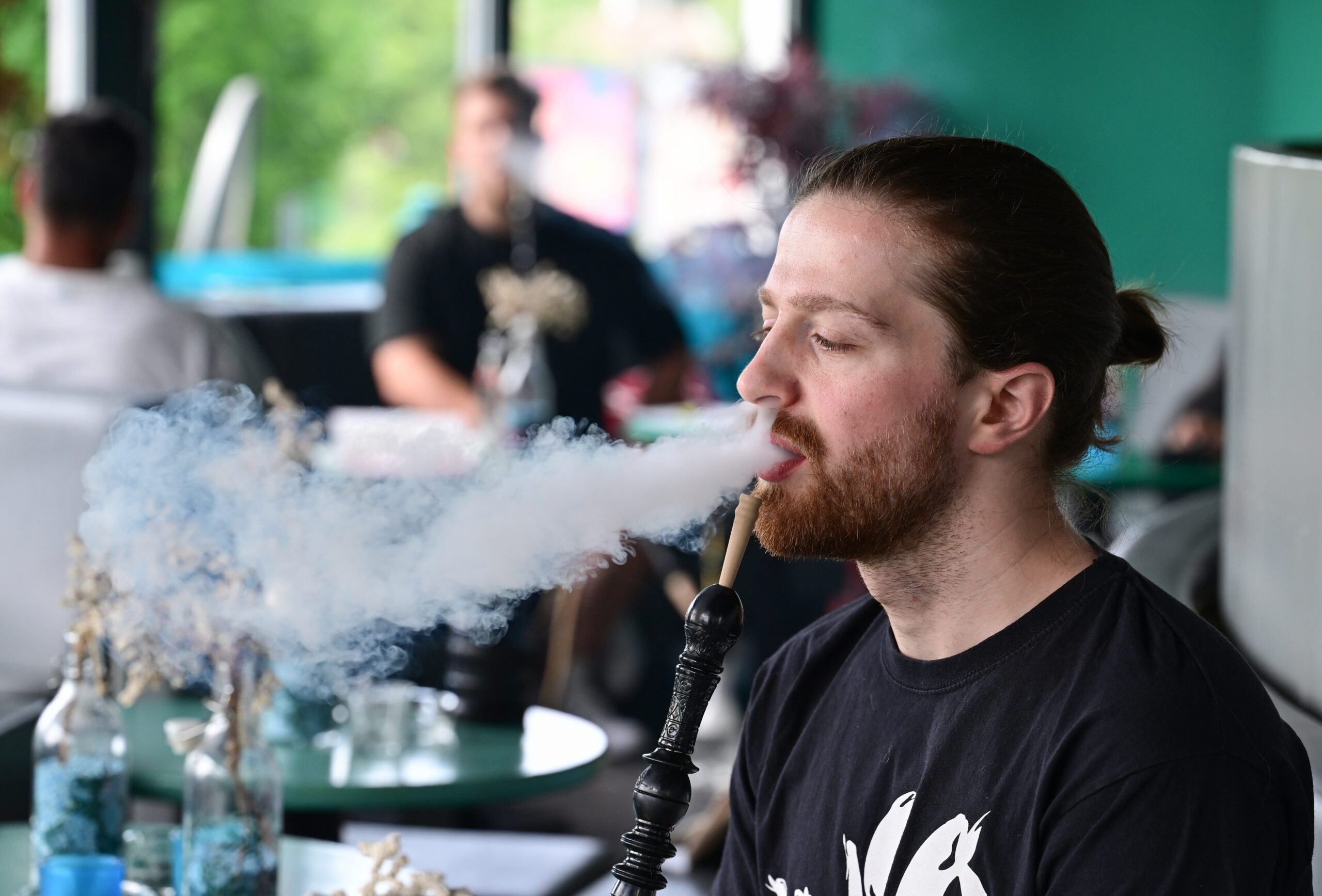 Ein Mann raucht in einer Shisha-Bar eine Shisha-Wasserpfeife.