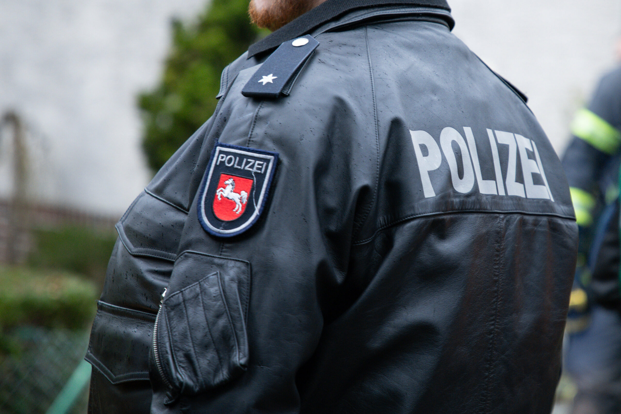Ein Beamter der Polizei Niedersachsen mit Schriftzug und dem Landeswappen auf der Polizeijacke.