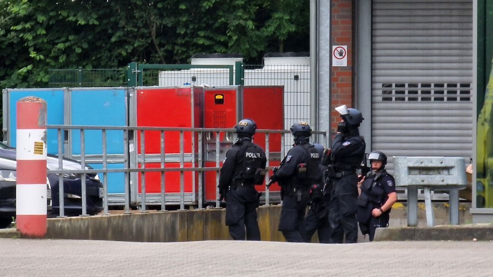 Polizisten stehen auf der Ladefläche eines Supermarkts.