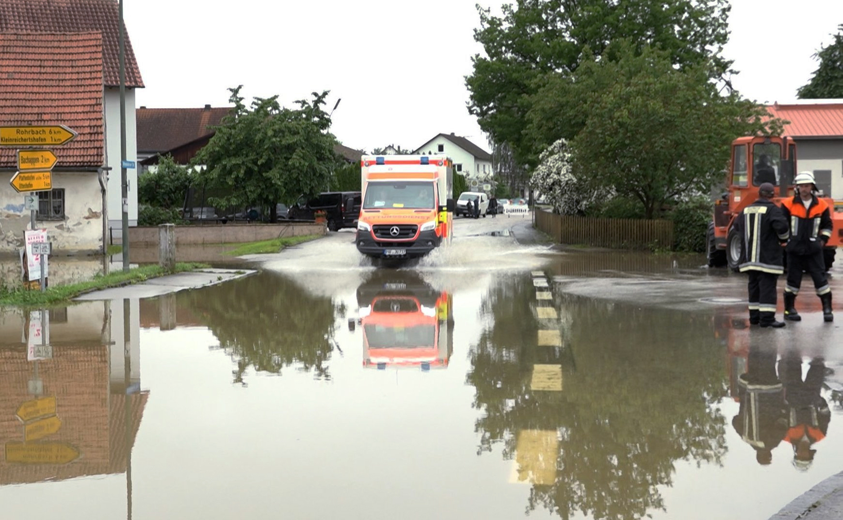 Ein Krankenwagen fährt über eine überschwemmte Straße in Pfaffenhofen an der Ilm.
