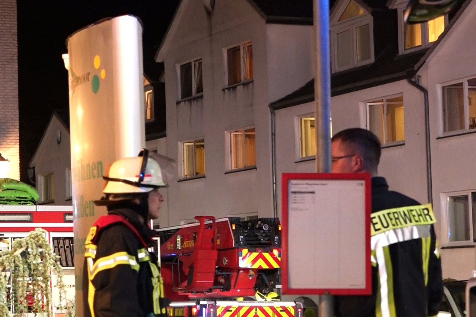 Einsatzkräfte der Feuerwehr stehen vor dem Seniorenheim in Oyten, in dem in der Nacht ein Feuer ausgebrochen war.