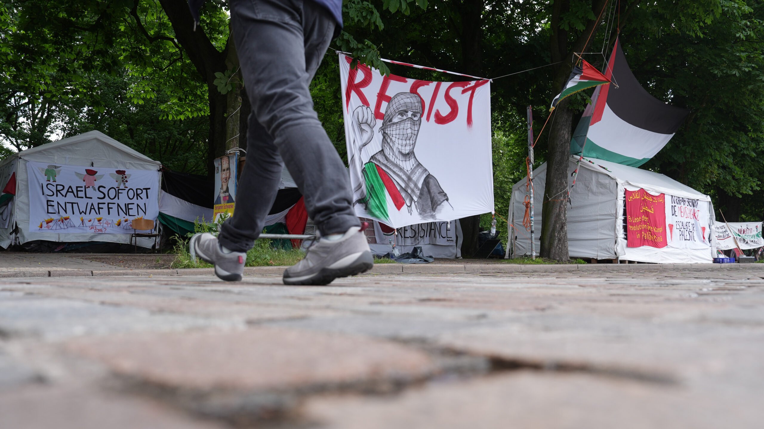 Ein Passant geht an der propalästinensischen Mahnwache nahe der Universität Hamburg auf der Parkanlage Moorweide vorbei.