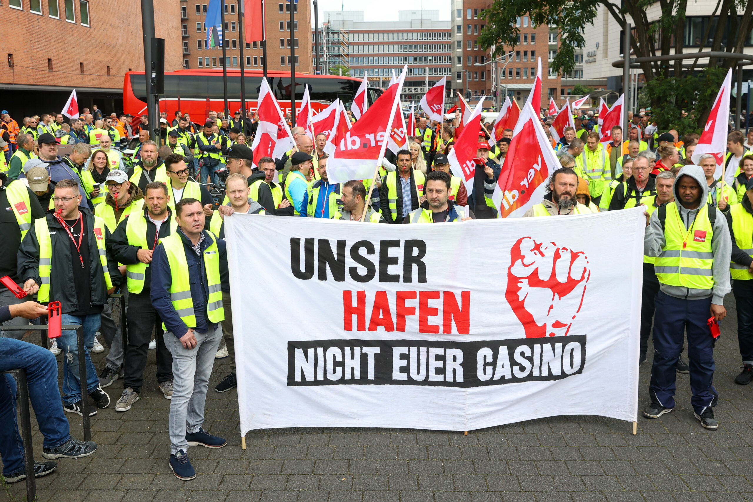 Vor Beginn einer Demonstration stehen streikende Hafenarbeiter bei einer Kundgebung zusammen.