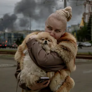 Frau flüchtet mit Hund auf Arm