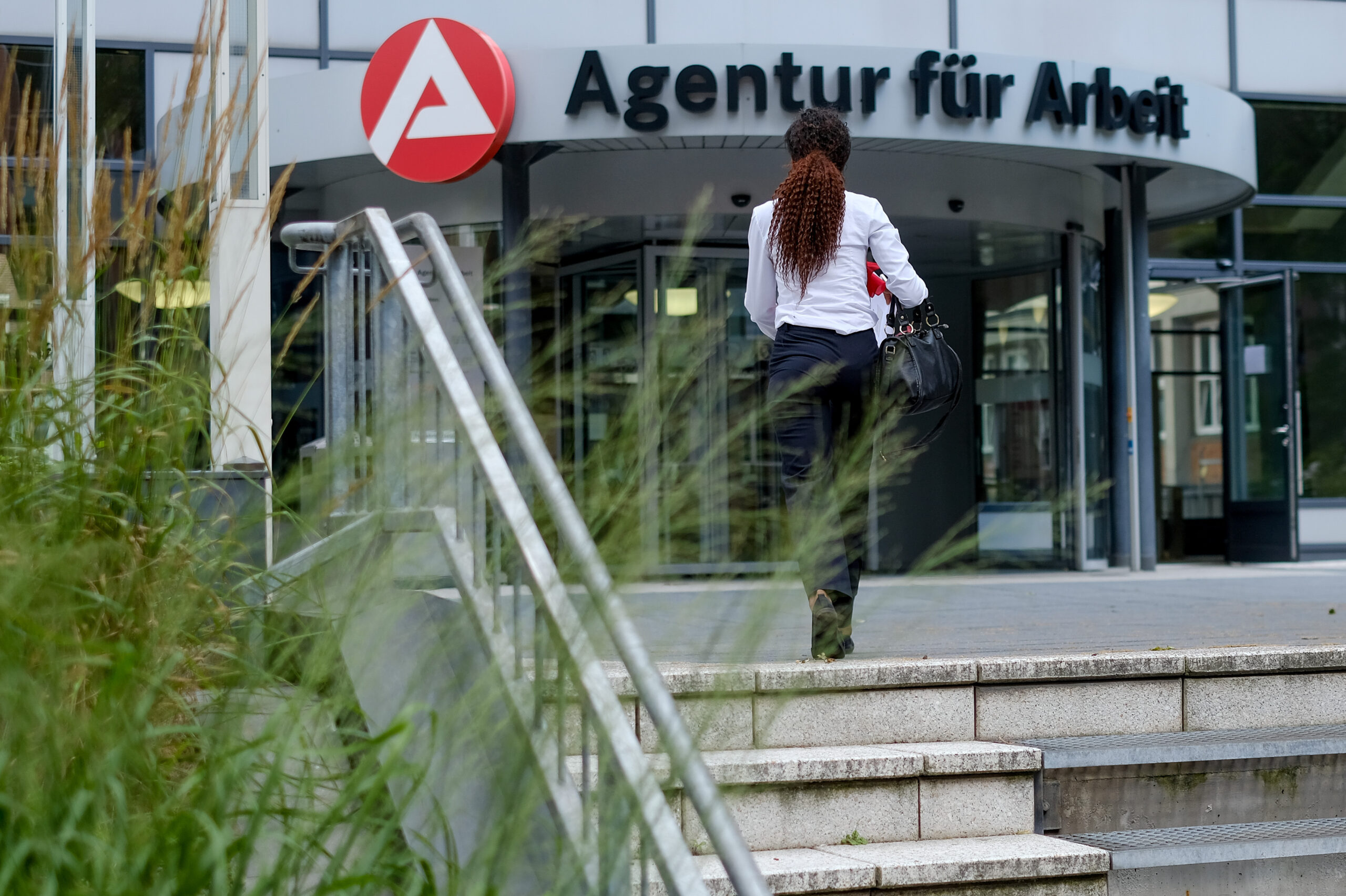 Eine Frau betritt in Hamburg das Gebäude der Agentur für Arbeit.