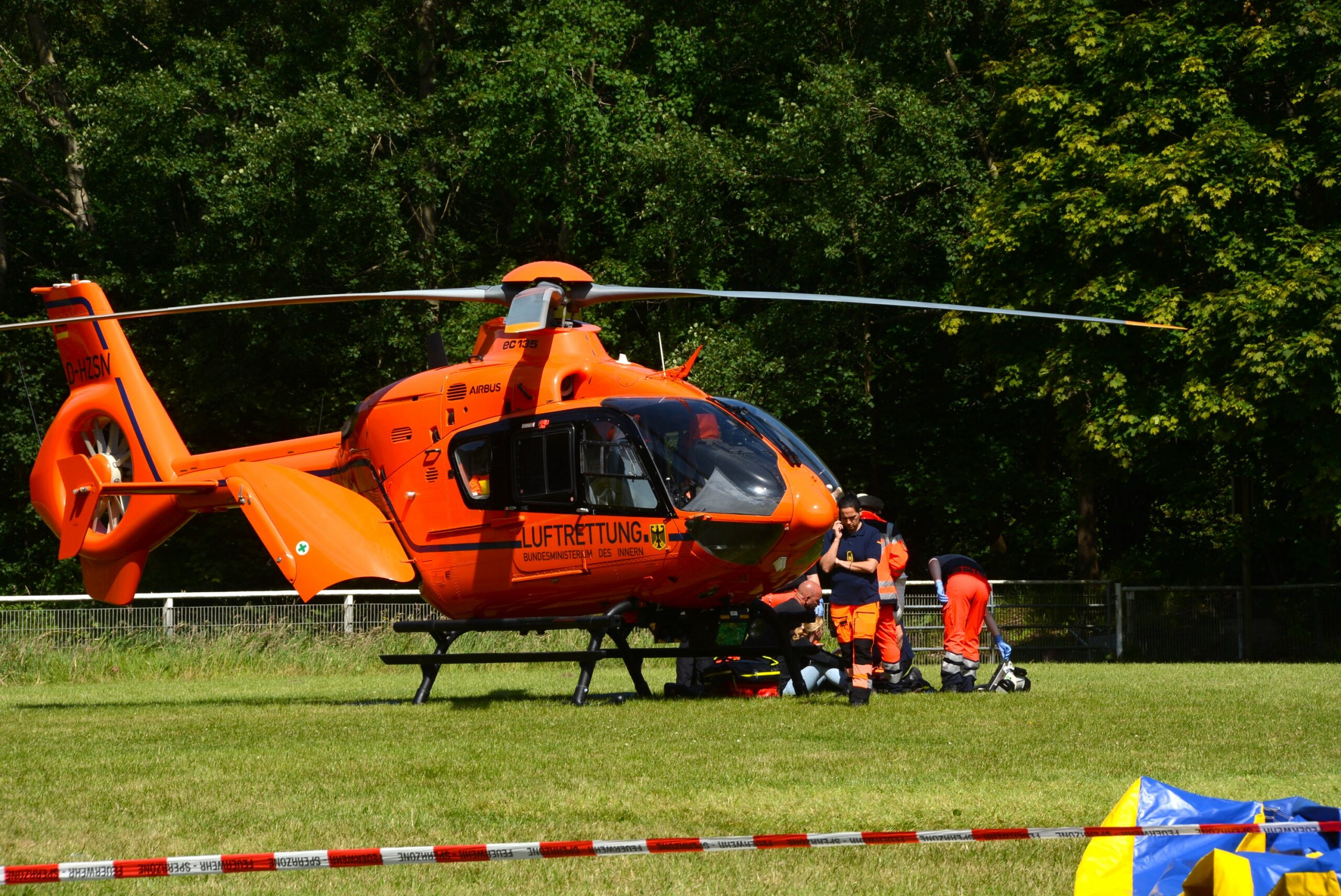 Orangefarbener Rettungshubschrauber auf einer Wiese