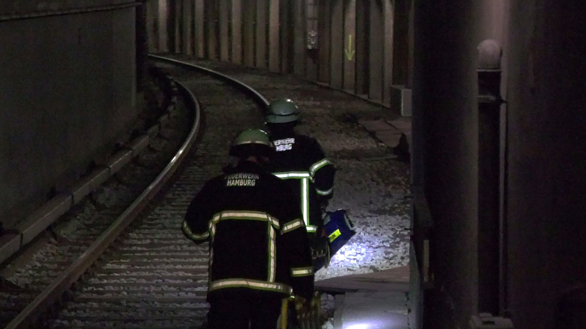 Feuerwehrkräfte eilen zu dem verletzten Mann im U-Bahntunnel.