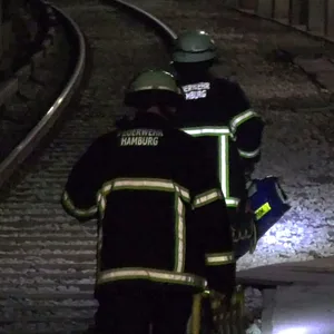Feuerwehrkräfte eilen zu dem verletzten Mann im U-Bahntunnel.