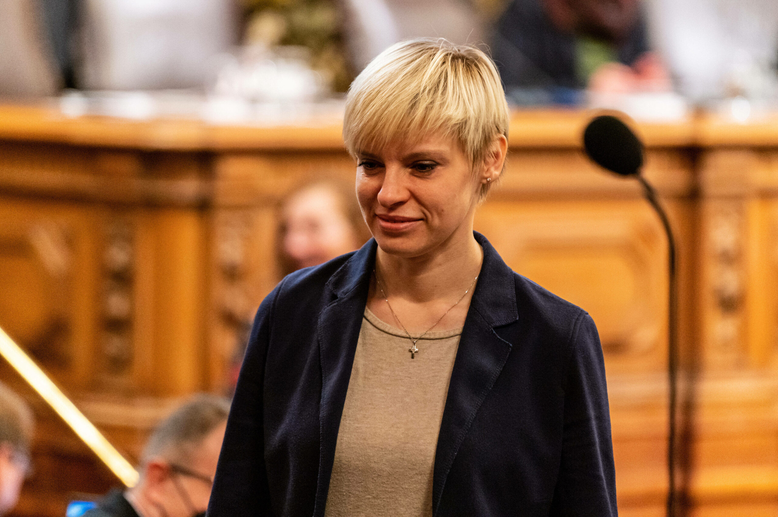 Junge Frau mit kurzen blonden Haaren an Rednerpult