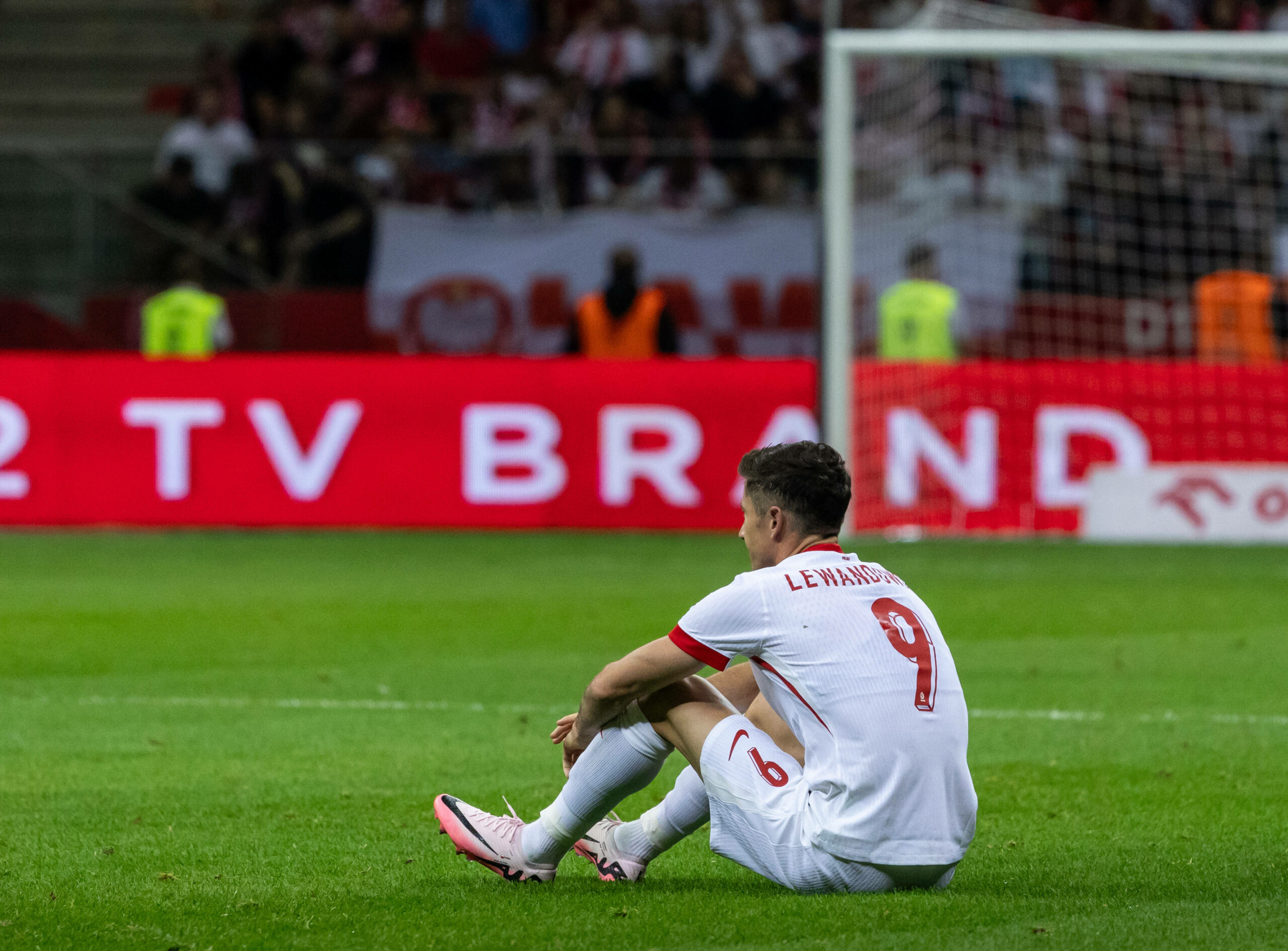 Robert Lewandowski sitz bedrückt auf dem Rasen