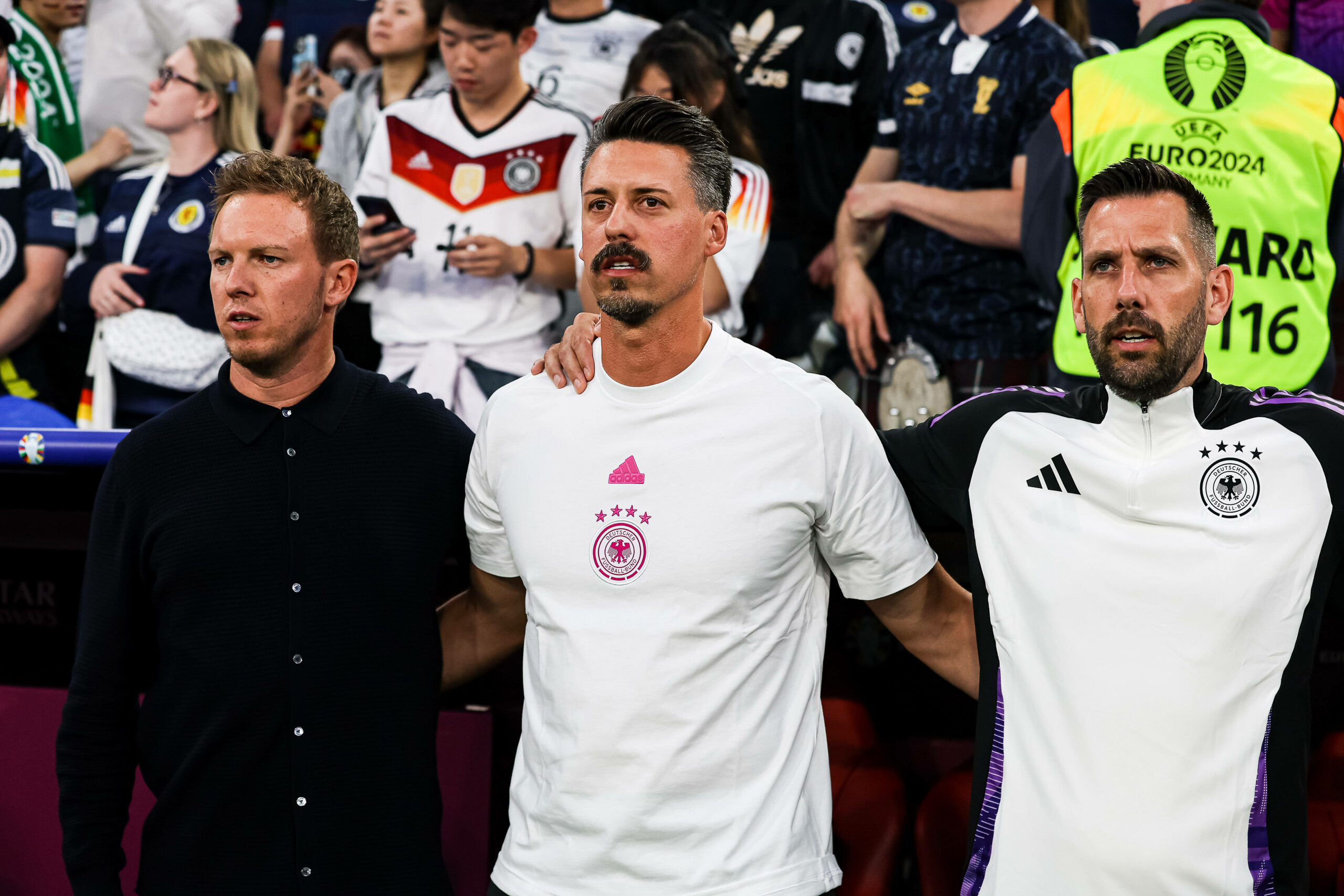 Julian Nagelsmann, Sandro Wagner und Mads Buttgereit singen die deutsche Nationalhymne im Stadion