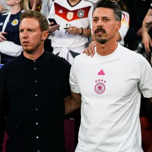 Julian Nagelsmann, Sandro Wagner und Mads Buttgereit singen die deutsche Nationalhymne im Stadion