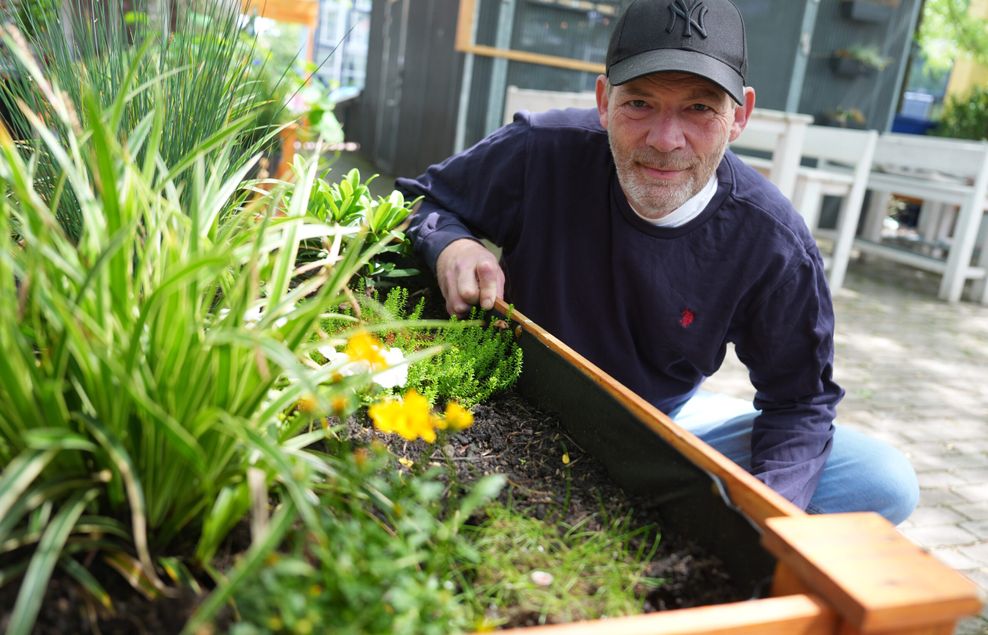 Michael Sarnhof, Betreiber «Kiez Garden», kniet neben einem Hochbeet im Biergarten