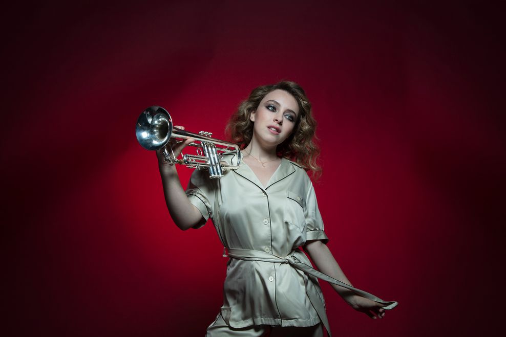 Lucienne Renaudin Vary trägt ein silberfarbenes Oberteil, sie hält eine Trompete in der Hand.