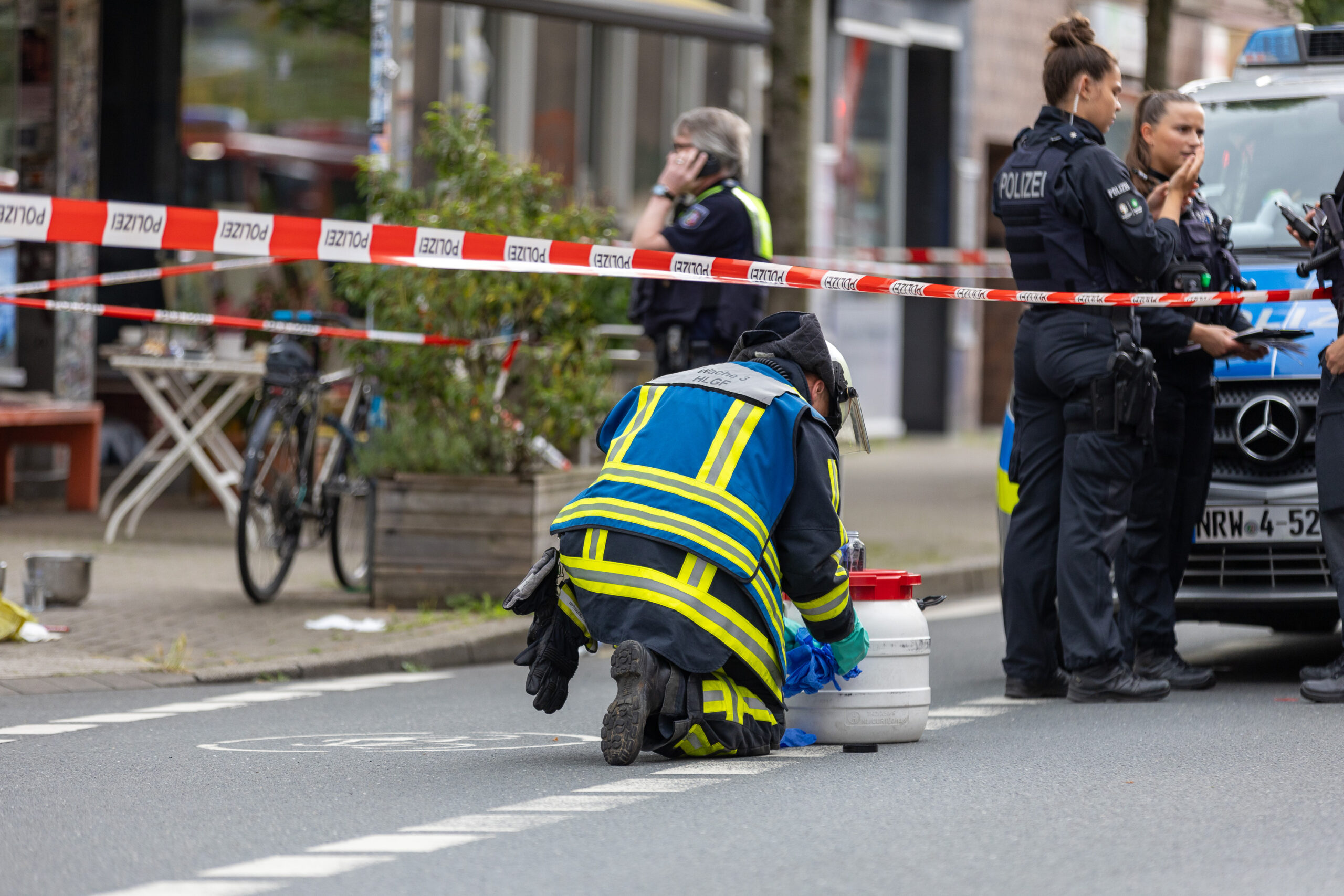 Bochum: Polizisten sind im Einsatz vor einem Bochumer Café, nachdem bei einem Angriff mit einer säurehaltigen Flüssigkeit im Außenbereich des Cafés mehrere Personen verletzt wurden.