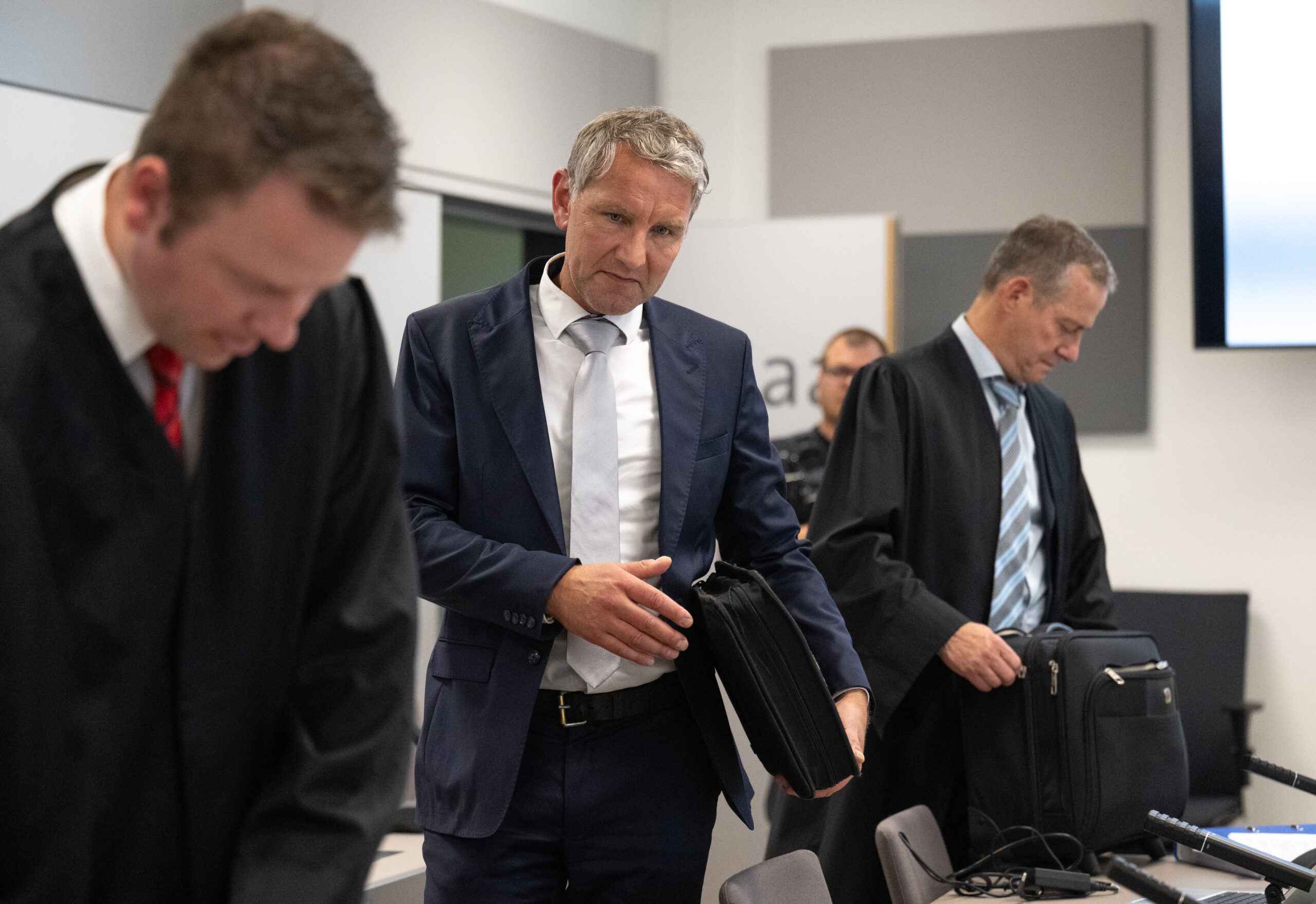 Björn Höcke (M.), Vorsitzender der Thüringer AfD, kommt nach seinen Anwälten Florian Gempe (l.) und Ralf Hornemann in den Saal des Landgerichts Halle/Saale.