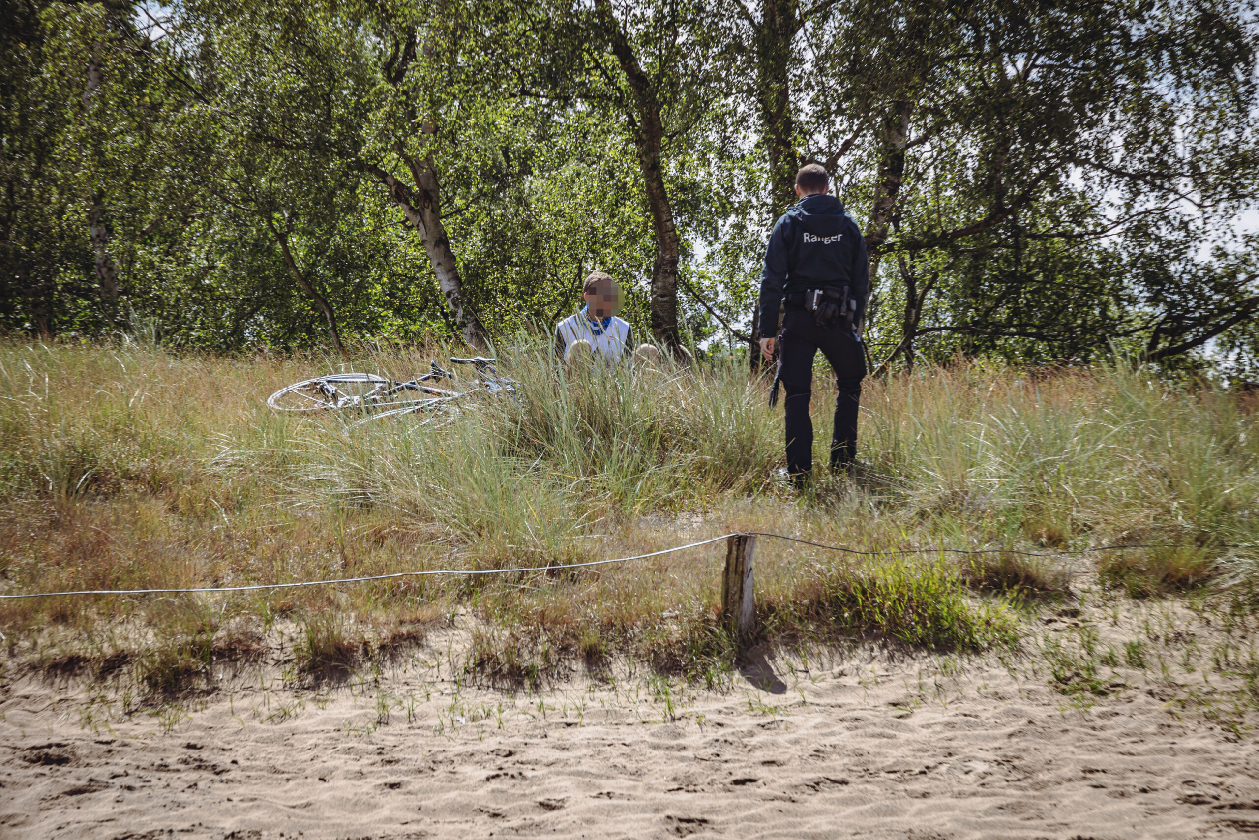 Radler hinter der Absperrung Boberger Düne