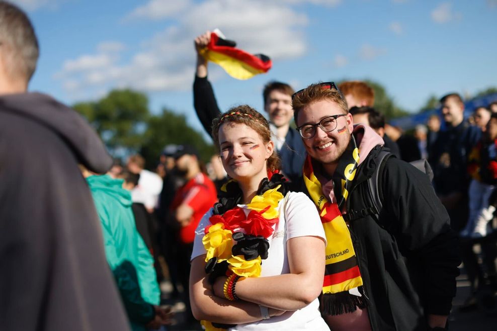 Farbe bekennen: Antonia (20) trägt Schwarz-Rot-Gold an den Armen, am Hals, im Gesicht, im Haar. Julian (22) setzt auf den klassischen Fanschal.