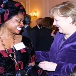 Sylvaina G. 2011 bei einem Empfang im Schloss Bellevue mit Bundeskanzlerin Angela Merkel (CDU).