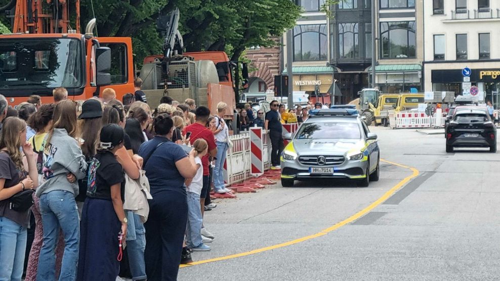 Die Swifties drängen vom Gehweg auf die Straße – die Polizei scheucht sie wieder zurück.