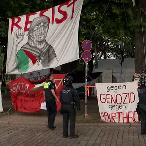 Polizisten hängen illegal angebrachte Banner am umstrittenen Palästina-Camp auf der Moorweide ab.