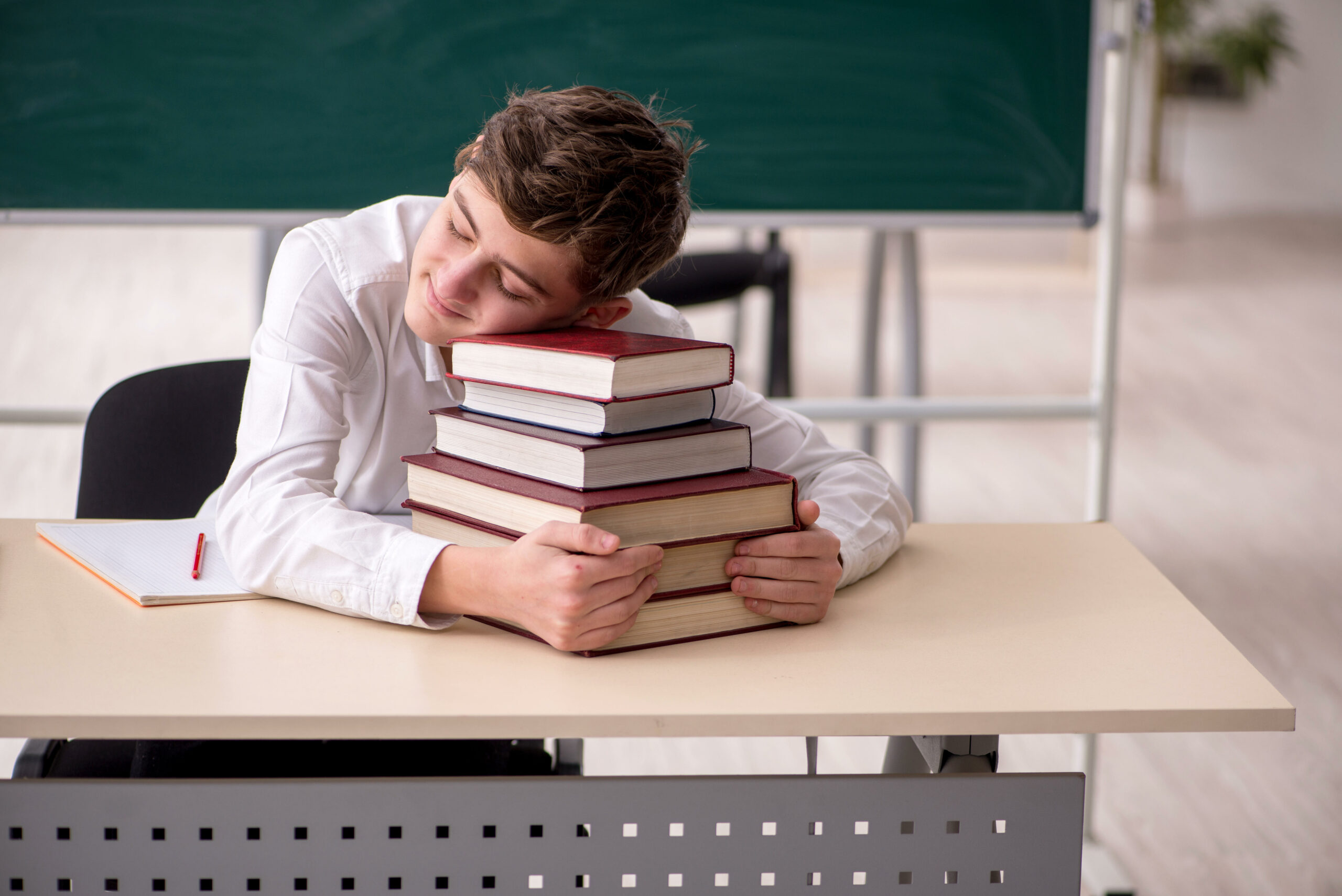 Schüler mit Kopf auf Bücherstapel