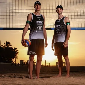 Nils Ehlers und Clemens Wickler stehen im Sonnenuntergang vor einem Beachvolleyballnetz